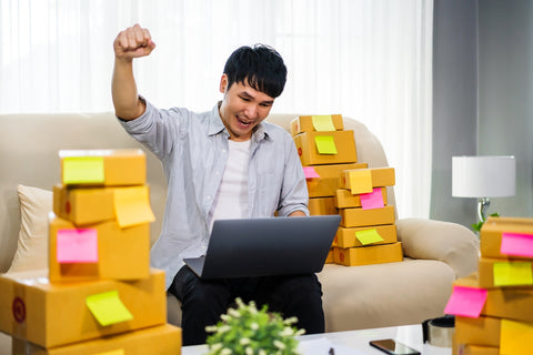 a man sitting on a couch in front of a laptop